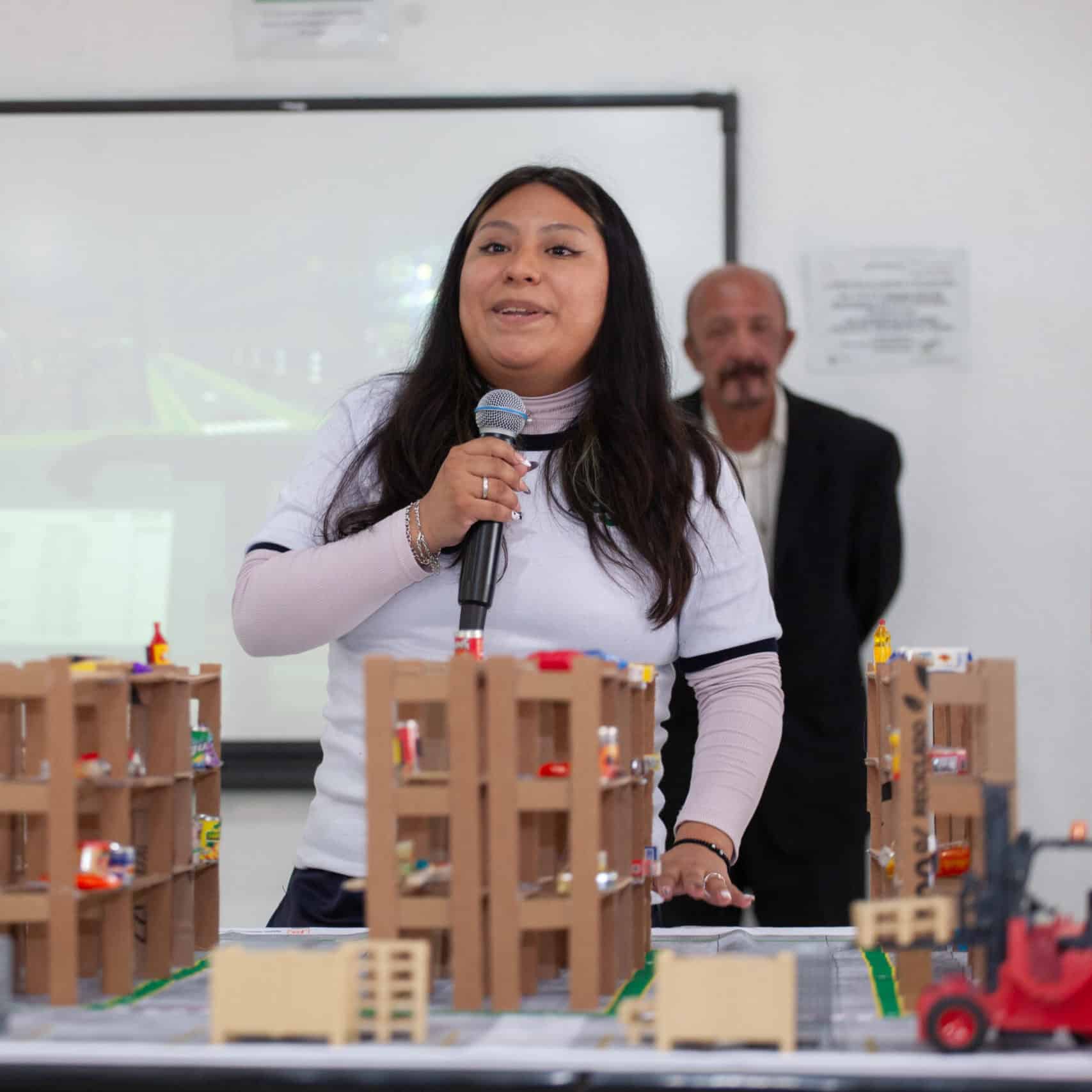 Student speaking on a microphone in a classroom.