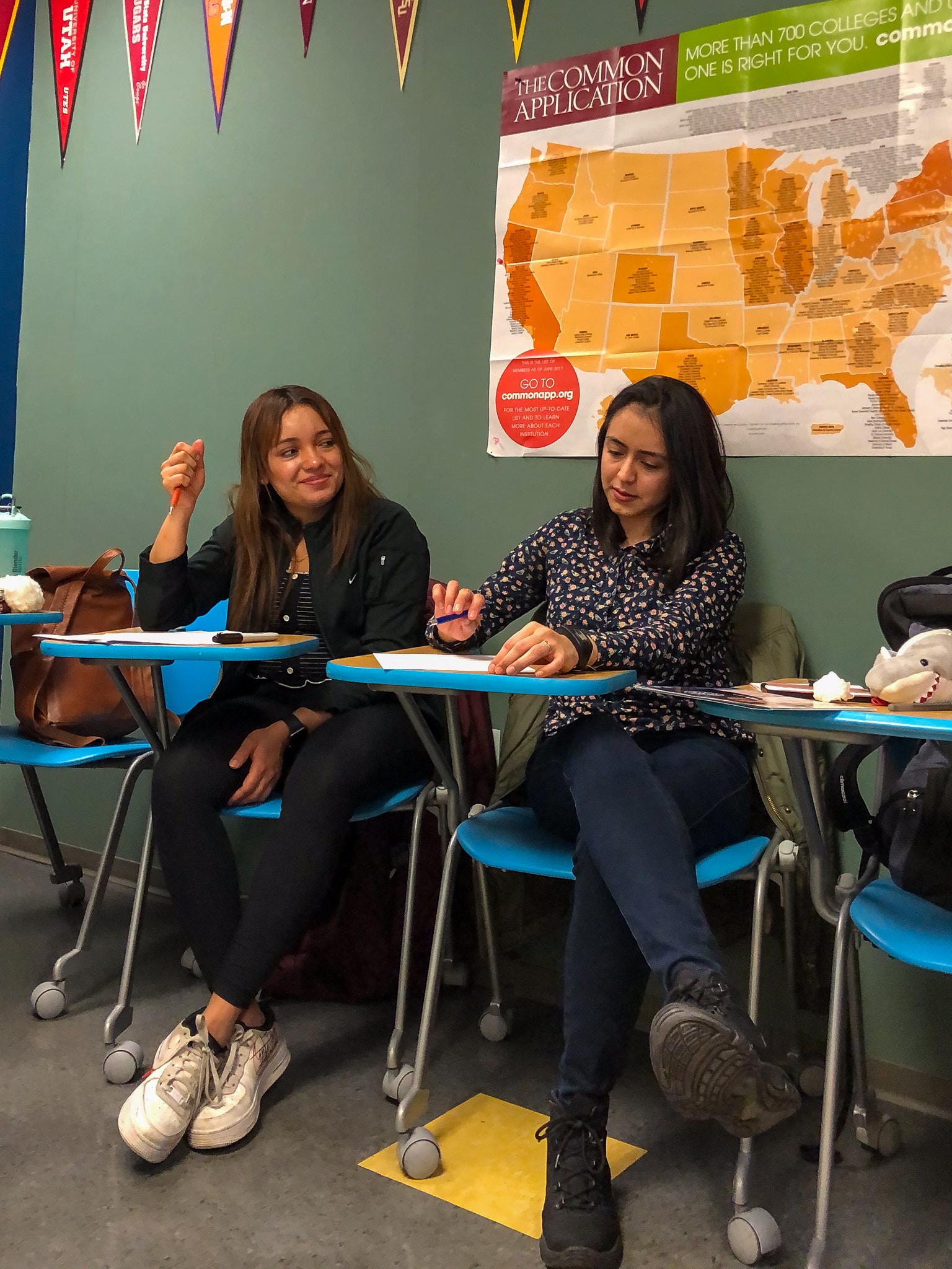 Young women sitting at desks in a classroom.